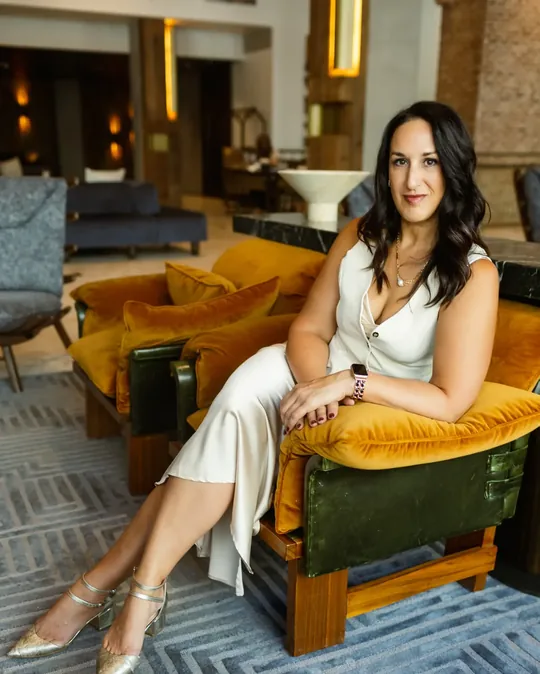 Kristin Darga, executive coach, seated in a gold armchair