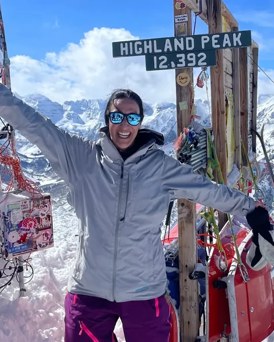 Kristin Darga with arms raised at the summit of Highland Peak, 12,392 feet